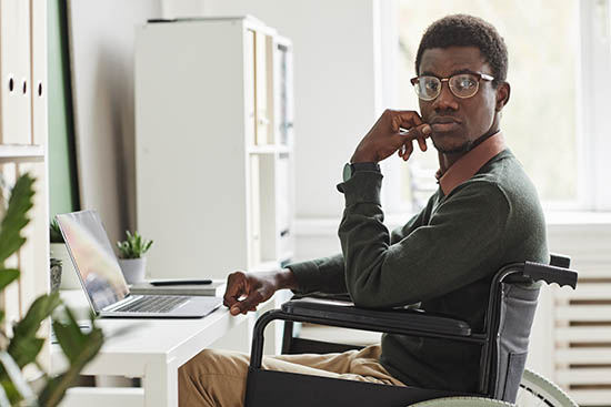 Student in wheelchair working on a laptop